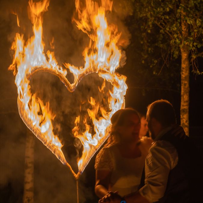 Hochzeitsfeuershow mit brennendem Herz und Brautpaar